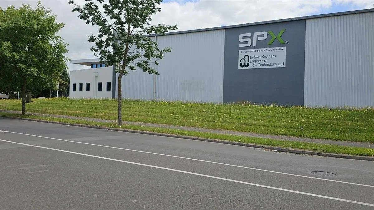 Overgrown grass verge outside a commercial warehouse frontage