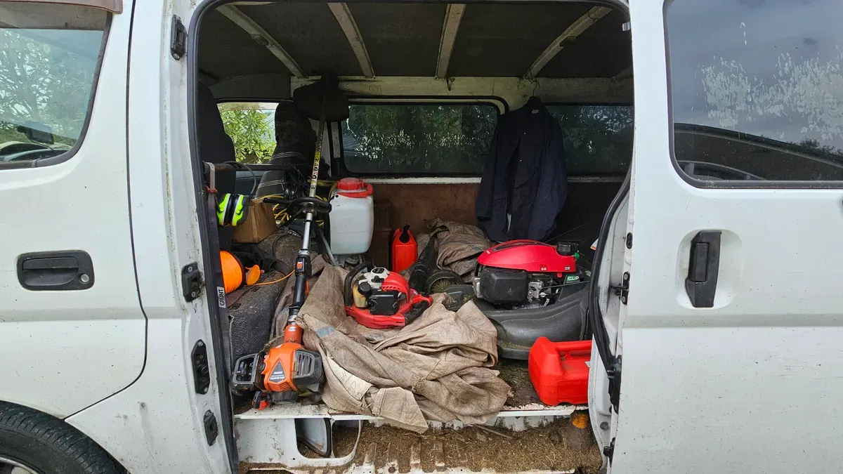 Van loaded with mowers, trimmers and fuel