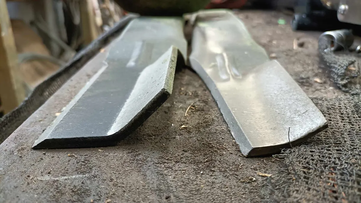 Two mower blades on the workbench