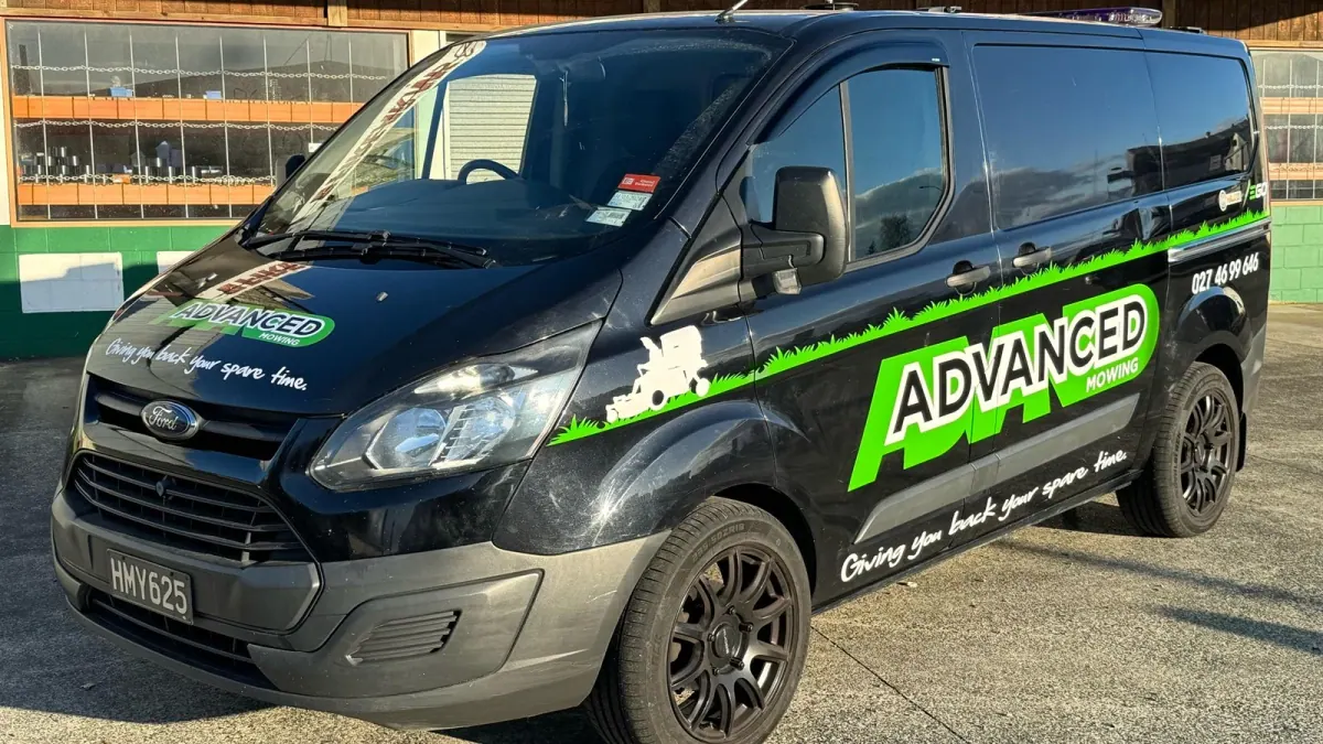 Advanced Mowing signwritten black van with the phone number on the side, the vehicle that does the talking on the street