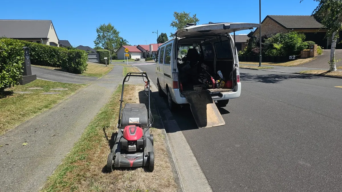 Honda mower on a berm beside the open work van