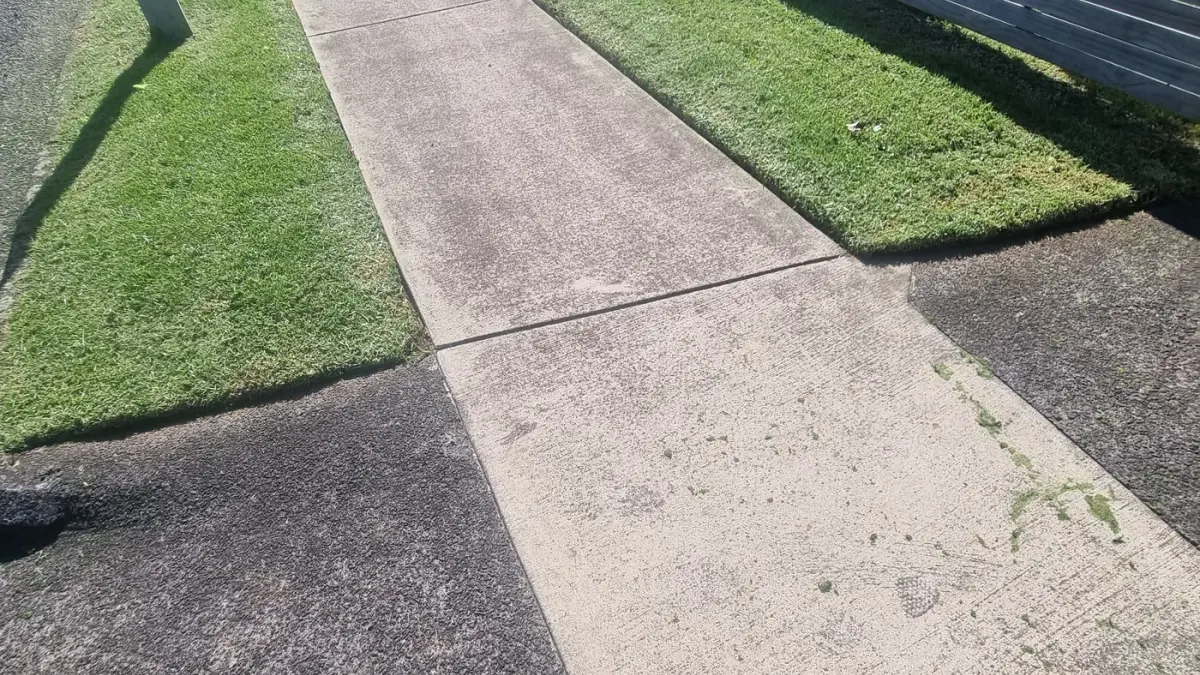 Crisp trimmed lawn edges along both sides of a concrete footpath