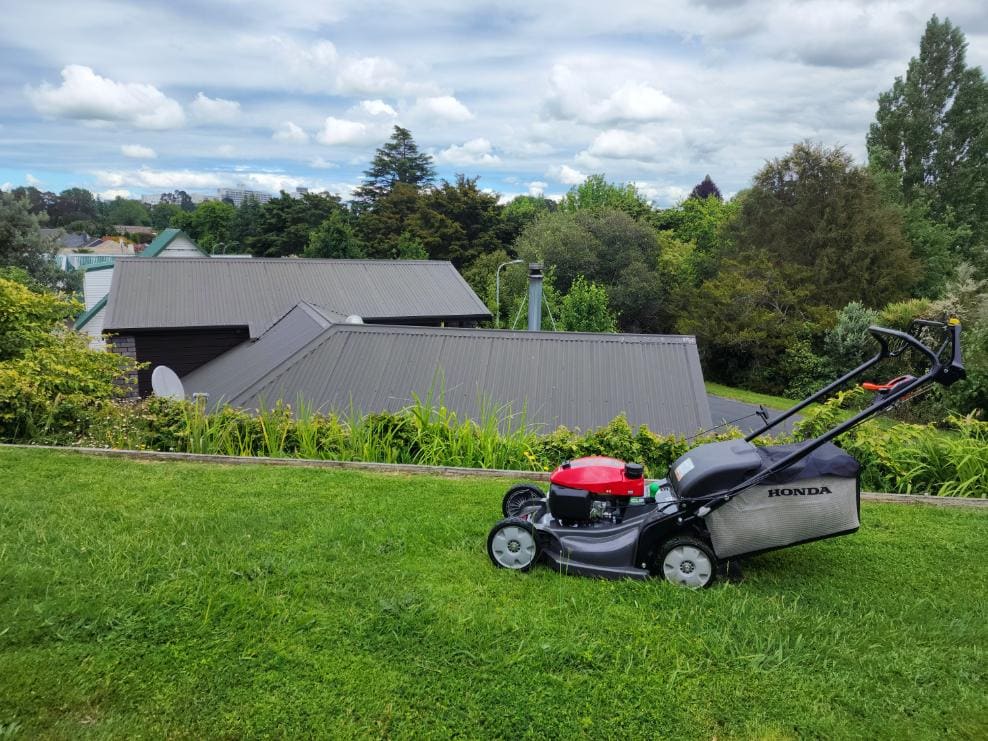 Honda mower on a freshly mown lawn above a house roof